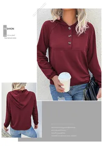 Detail of wine red hoodie featuring three dark decorative buttons and raglan sleeves