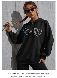Detail of street style black hoodie with bold DRIP lettering and blue butterfly prints