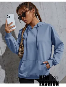 Detail of greyish-blue oversized hoodie featuring ribbed cuffs and front kangaroo pocket