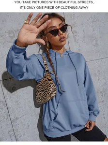 Detail of blue oversized hoodie with drawstring hood and front kangaroo pocket