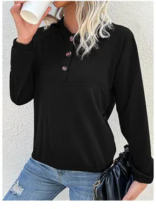 Detail view of the black hoodie featuring a buttoned neckline and ribbed cuffs