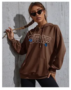 Detail of butterfly print and white DRIP lettering on a brown oversized hoodie