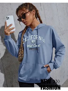 Close-up of Morandi blue hoodie with white California West Coast lettering and kangaroo pocket