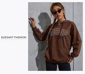 Detail of oversized brown hoodie featuring white DRIP lettering and blue butterflies