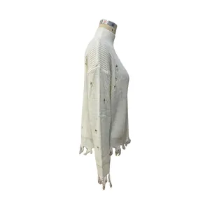 Détail d'un pull à col roulé blanc cassé avec maille vieillie et ourlet à franges