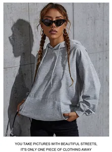 Detailed view of gray oversized hoodie showing the kangaroo pocket and adjustable drawstrings