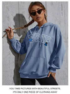 Detail of blue oversized hoodie featuring butterfly print and DRIP lettering text