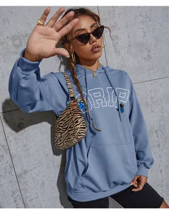 Detail of blue hoodie with white DRIP lettering and butterfly prints in a streetwear style