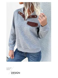Detail of grey diamond quilted fabric sweatshirt with brown collar and metal snap buttons