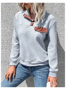 Close-up of textured grey sweatshirt with brown patchwork collar and button detail