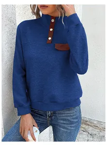 Detail of waffle knit fabric and stand collar with brown buttons on navy sweatshirt