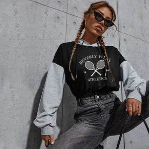 Women's cropped grey and black contrast hoodie featuring varsity letter print
