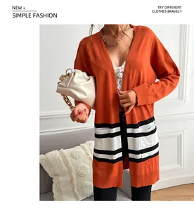 Detail of orange long sleeve knit cardigan featuring black and white striped patch pockets