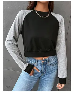 Détail des manches raglan contrastées noires et grises sur un sweat-shirt court cintré