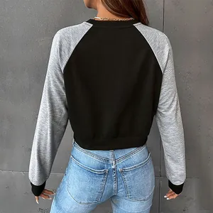 Sweat court à manches raglan noir et gris porté avec un jean taille haute