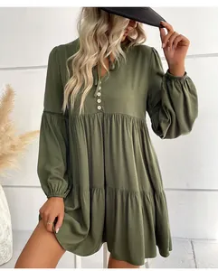 Dettaglio dell'abito verde oliva con scollo a V, bottoni in legno e balze