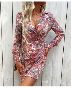 Dettaglio dell'abito a portafoglio rosso paisley con scollo a V e stampe etniche vivaci