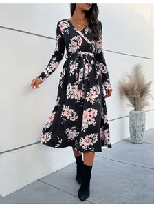 Detail of V-neck wrap dress with pink floral print on black fabric and waist tie
