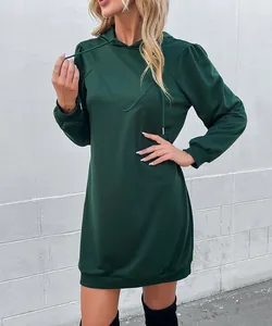 Detail of dark green hoodie dress featuring lantern sleeves and ribbed cuffs on fabric