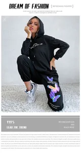 Detail of black hoodie tracksuit featuring iridescent butterfly print and logo text