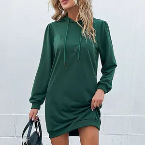 Deep green long sleeve hooded mini dress with drawstring and lantern sleeves on a model