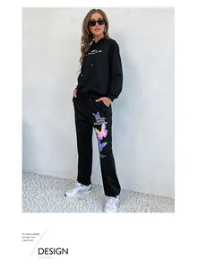 Detail of black hoodie tracksuit featuring colorful butterfly prints and street style typography