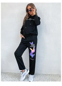 Detail of black two-piece tracksuit featuring purple butterfly print and drawstring hood