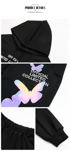 Close-up of butterfly print and text detail on a black hooded sweatshirt set