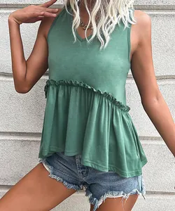 Side view of green sleeveless V-neck top with ruffled hem paired with denim shorts