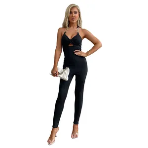 Tuta nera aderente con scollo all'americana, catene dorate e dettagli cut-out sexy