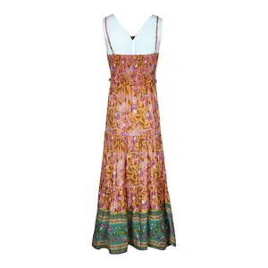Detail of bohemian floral maxi dress featuring smocked bodice and thin straps in orange