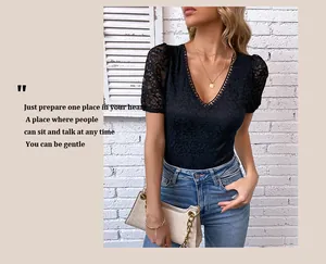 Detail of elegant black V-neck lace bodysuit with floral embroidery and gold chain handbag