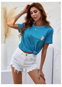 Detail of colorful T-shirt featuring perfume and floral print with frayed denim shorts