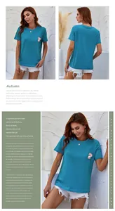 Detailed view of blue T-shirt featuring colorful floral embroidery on the chest pocket