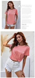 Detail showing coral pink cotton T-shirt with floral embroidery and white denim shorts