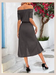 Detailed back view of charcoal grey off-shoulder dress with side slit in resort setting