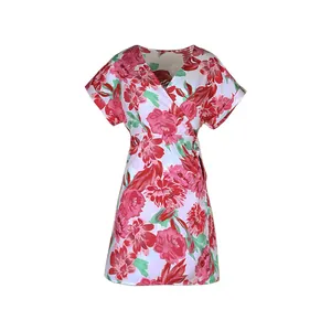 Close-up of white wrap dress featuring red and pink floral print with green leaf details