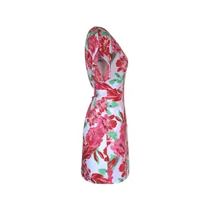 Detail view of floral print dress with red flowers and green leaves on white fabric