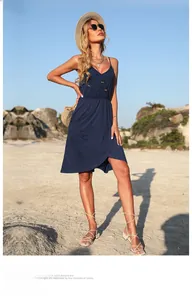 Détail d'une robe bleu marine à col en V avec boutons marrons sur une plage