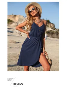 Détail de la robe bleu marine à col en V avec boutons et coupe trapèze dans un décor de plage