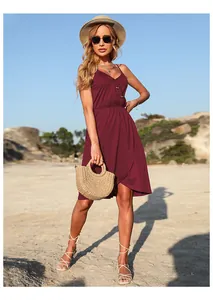 Détail de robe bordeaux à col en V avec boutons et jupe portefeuille en décor de vacances