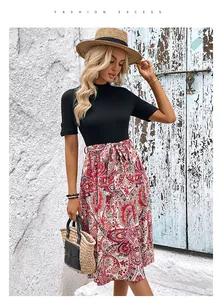 Détail d'une robe style deux-pièces avec haut noir côtelé et jupe à motif paisley