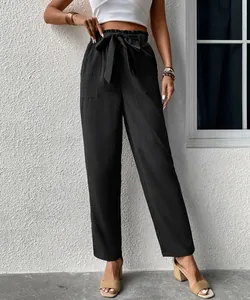 Detail of high waisted black trousers featuring a paperbag waist with a matching belt