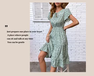 Detail of green ditsy floral dress featuring V-neckline with ties and ruffle sleeves