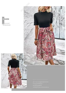 Détail de robe trapèze avec haut en maille noire et jupe patchwork imprimé paisley