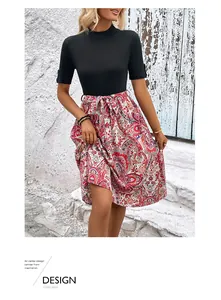 Détail de robe trapèze d'été avec manches noires et jupe à imprimé paisley rouge