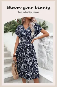 Détail d'une robe midi bleu marine à pois avec col en V et ceinture à la taille ajustée