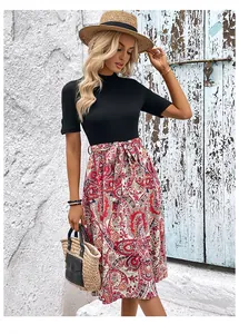 Détail de robe patchwork trapèze avec haut noir et jupe à imprimé cachemire rouge