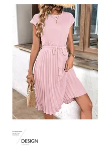 Detail of pink pleated summer dress featuring a waist tie and light breathable fabric