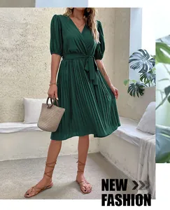 Detail of dark green V-neck pleated dress with tie waist and puff sleeves for summer